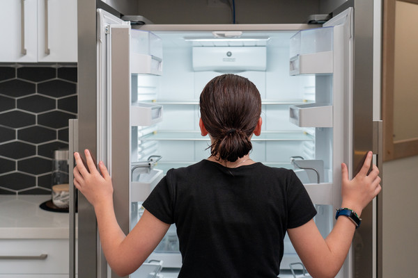 Frau vor leeren Kühlschrank